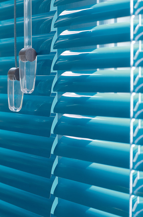 Nærbilde av lyseblå horisontale persienner med gjennomsiktige plastikk-snorer som fanger lyset.