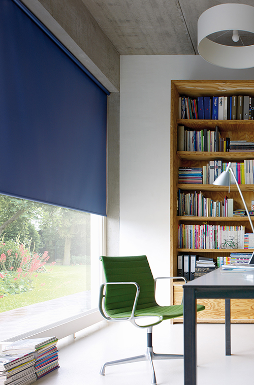 Moderne kontor med blå rullegardin, grønn stol, bokhylle i tre og stort vindu.