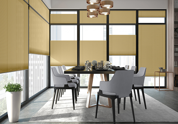 Elegant spisestue med store vinduer, gyldne plisségardiner, moderne stoler og spisebord i tre.